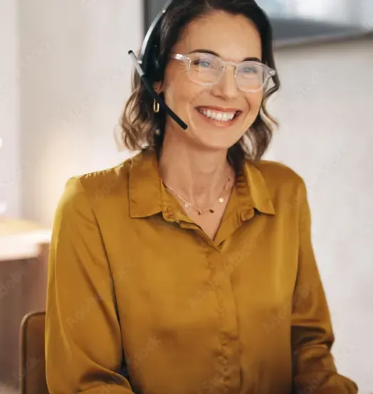 A smiling customer adviser wearing a headset in the office.